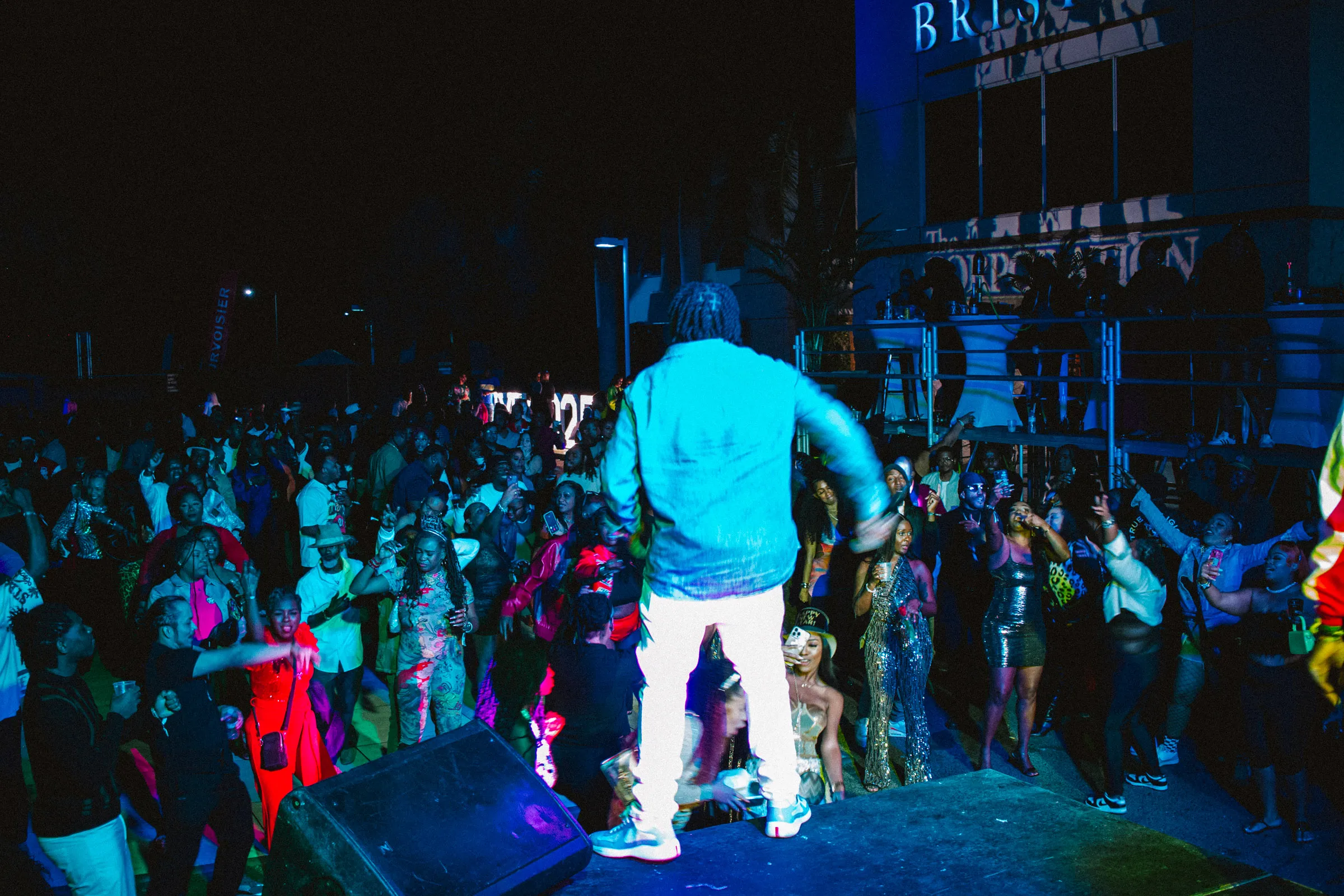 Young urban professional celebrating with a premium cocktail at The Corporation NYE Nassau